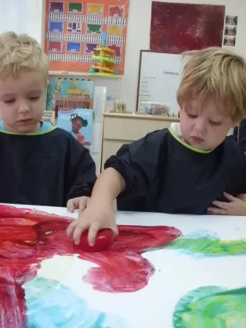 Two preschool children creating a collaborative painting.