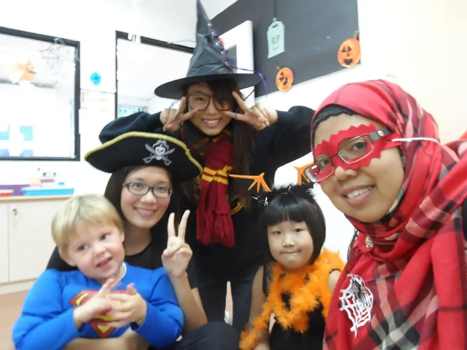 Children and adults posing together in Halloween costumes.