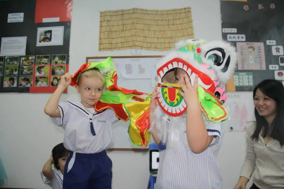 两名学龄前儿童试穿色彩缤纷的舞狮服饰。