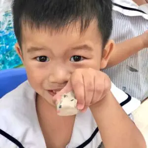 創造的な学びの中で小さな粘土の人形を持つナーサリー2の子ども