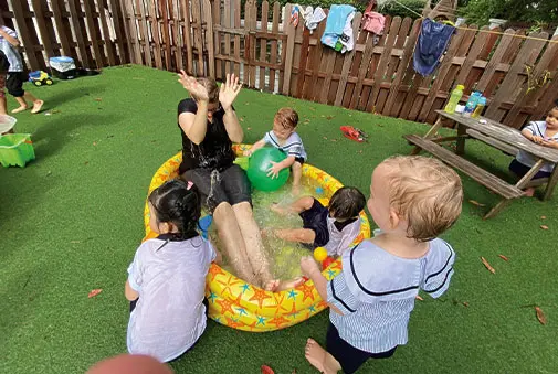 Toddlers enjoying sensory water play outdoors at Pegasus International Preschool
