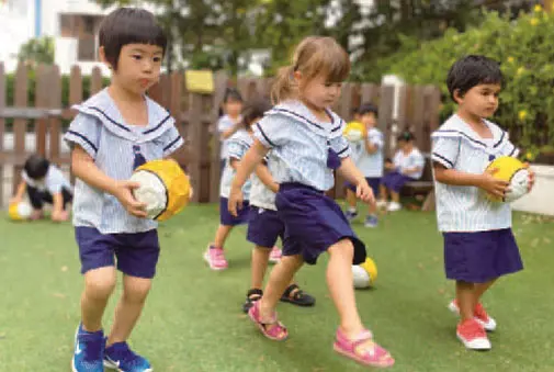 在 Pegasus 国际幼儿园户外踢足球的幼儿园孩子
